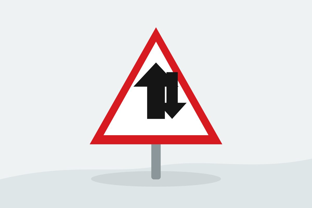 Eigenständig gezeichnetes Verkehrszeichen mit einem roten Dreieck mit zwei entgegengesetzten schwarzen Pfeilen.